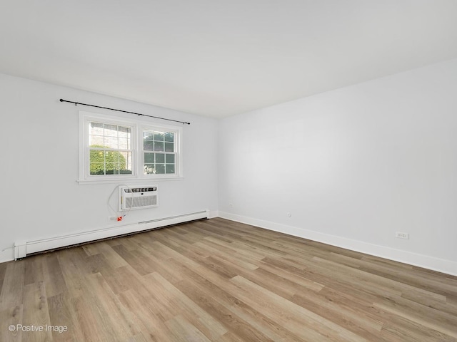 unfurnished room featuring a wall mounted air conditioner, a baseboard radiator, and light hardwood / wood-style flooring