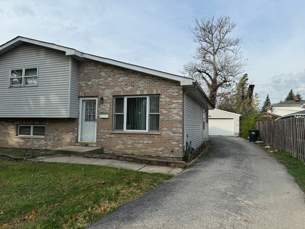 view of front of house with an outdoor structure, a garage, and a front lawn