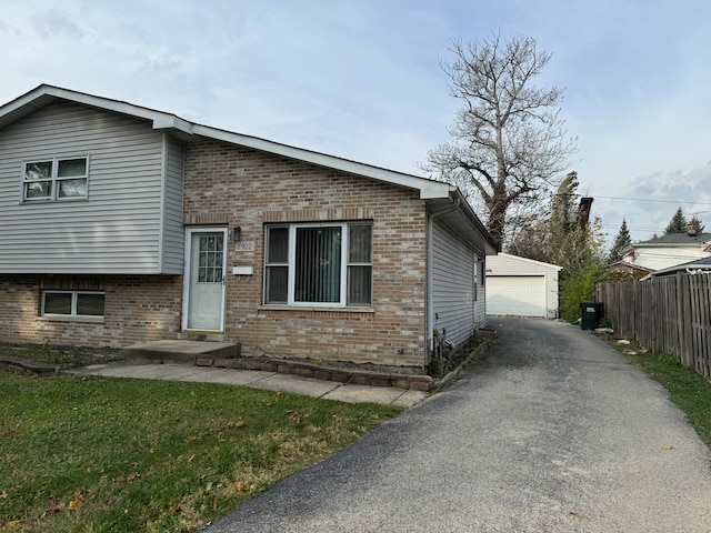 view of front of house with an outdoor structure, a garage, and a front lawn