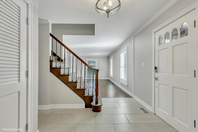 tiled entryway featuring crown molding