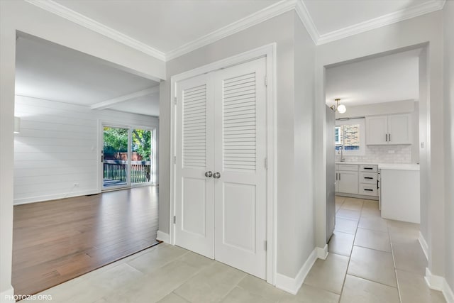 corridor featuring sink, crown molding, and light hardwood / wood-style flooring