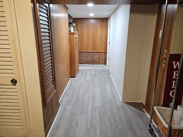 hall featuring wood walls and light wood-type flooring