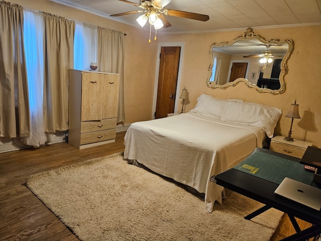 bedroom featuring ornamental molding, dark hardwood / wood-style flooring, and ceiling fan