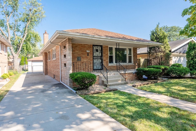 bungalow-style house with a front yard, a porch, an outbuilding, and a garage