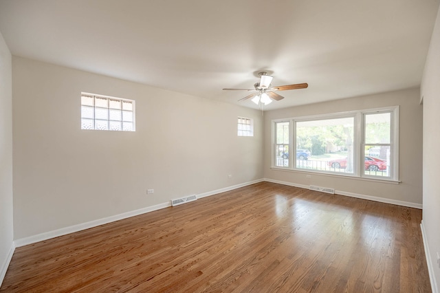 unfurnished room featuring hardwood / wood-style flooring, a healthy amount of sunlight, and ceiling fan