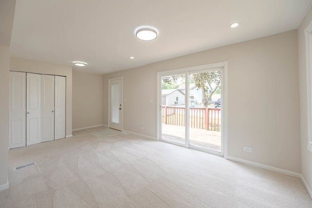 unfurnished bedroom with a closet, access to outside, and light colored carpet