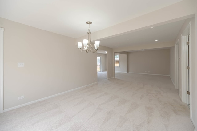 carpeted spare room featuring a chandelier