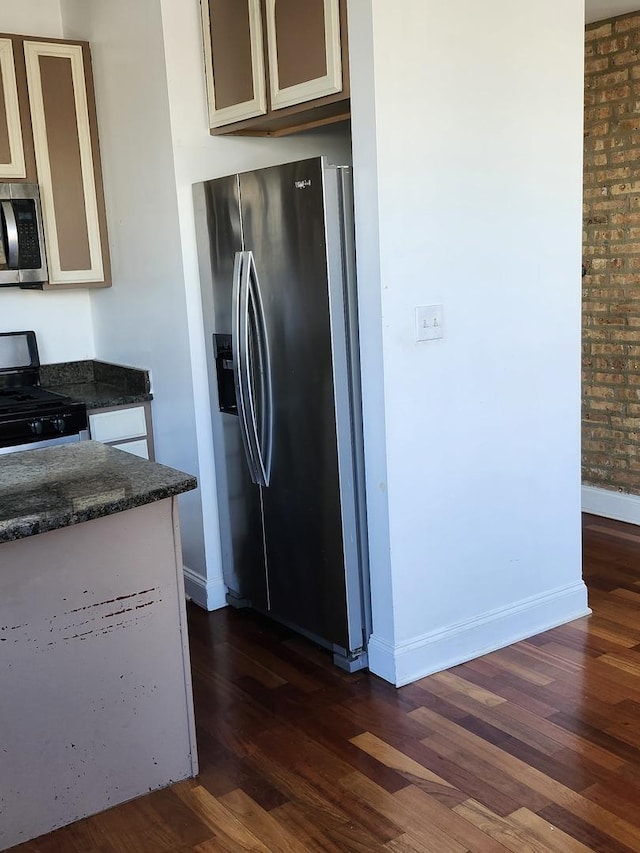 6410 N Hoyne Ave Unit 3E, Chicago, IL 60645 - kitchen featuring appliances with stainless steel finishes, dark wood-type flooring, dark stone counters, and baseboards