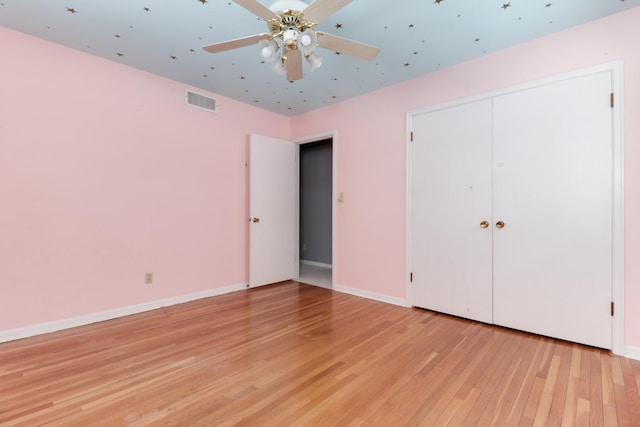 unfurnished bedroom featuring ceiling fan, light wood-type flooring, and a closet