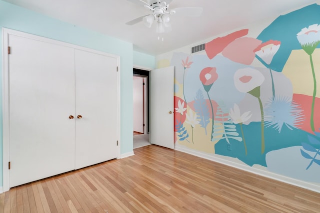 unfurnished bedroom featuring ceiling fan, light hardwood / wood-style floors, and a closet