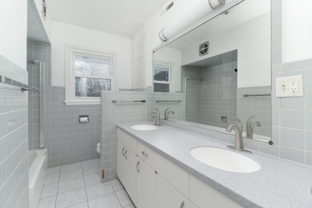 bathroom featuring tile patterned flooring, vanity, toilet, and tile walls