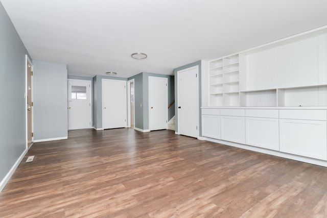 unfurnished living room with dark hardwood / wood-style flooring