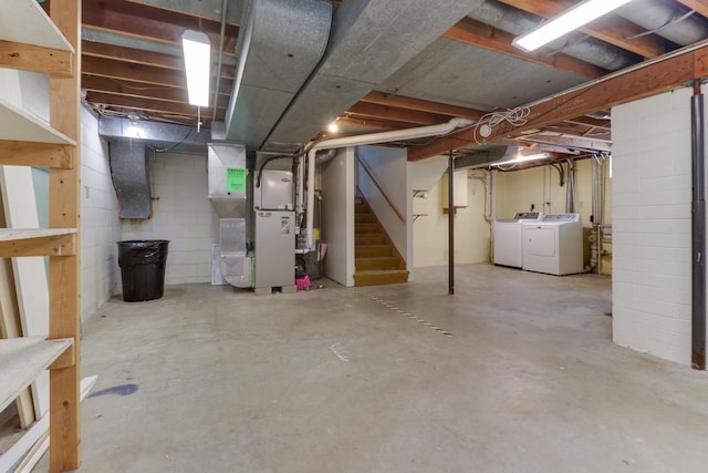 basement featuring heating unit and washer and clothes dryer