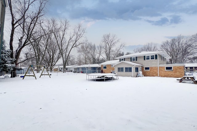 snowy yard featuring a trampoline