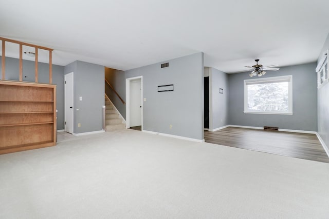 unfurnished living room featuring light colored carpet and ceiling fan