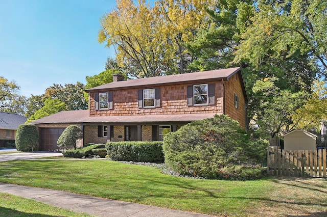 colonial house featuring a front yard and a garage