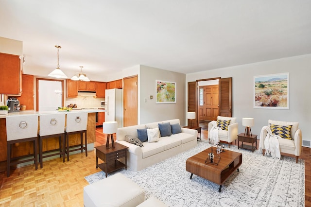 living room featuring a chandelier and light parquet floors