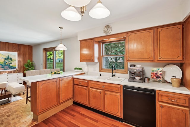 kitchen featuring dishwasher, sink, light hardwood / wood-style flooring, kitchen peninsula, and pendant lighting