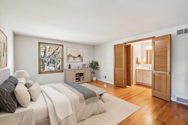 bedroom featuring connected bathroom and hardwood / wood-style floors