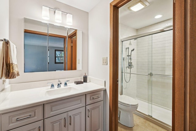 bathroom with tile patterned flooring, vanity, toilet, and a shower with shower door