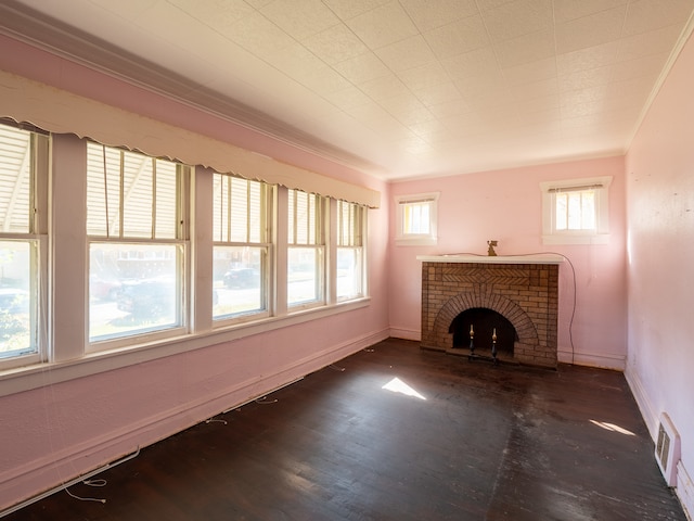 unfurnished living room with a brick fireplace, ornamental molding, and dark hardwood / wood-style flooring