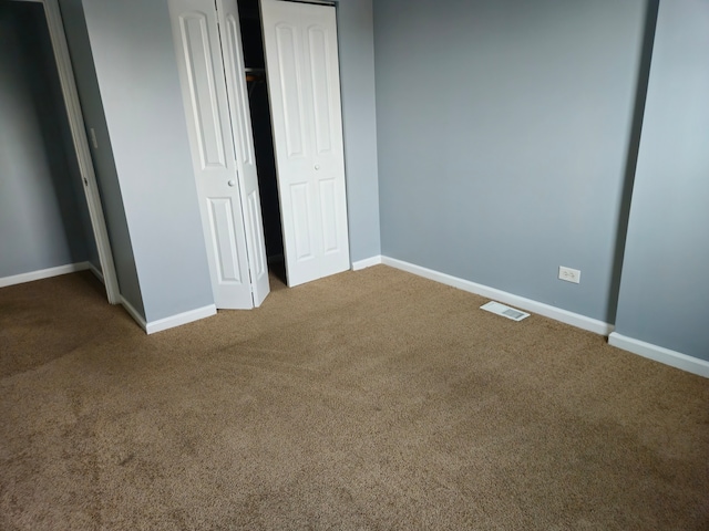 unfurnished bedroom with a closet and carpet