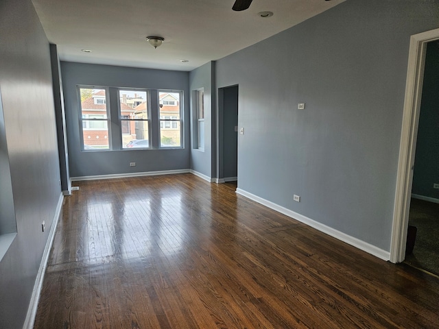 empty room featuring dark wood-type flooring and ceiling fan