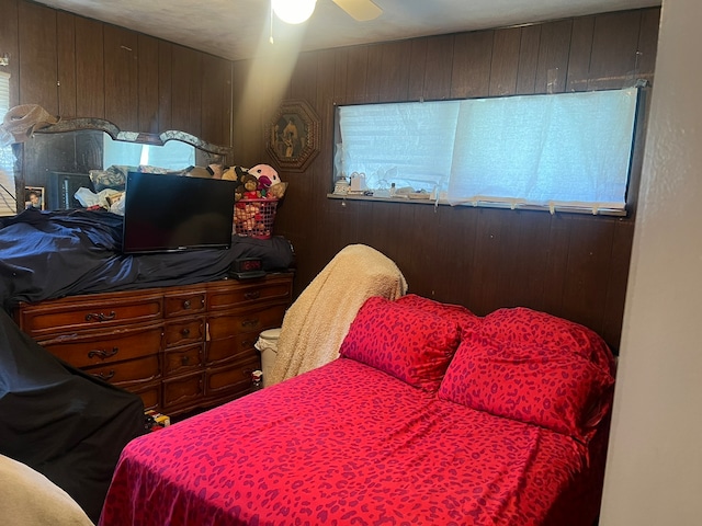 bedroom with wooden walls and ceiling fan