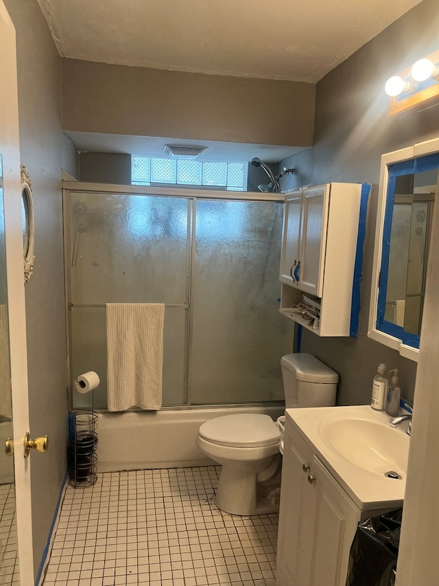 full bathroom with toilet, vanity, tile patterned floors, and shower / bath combination with glass door