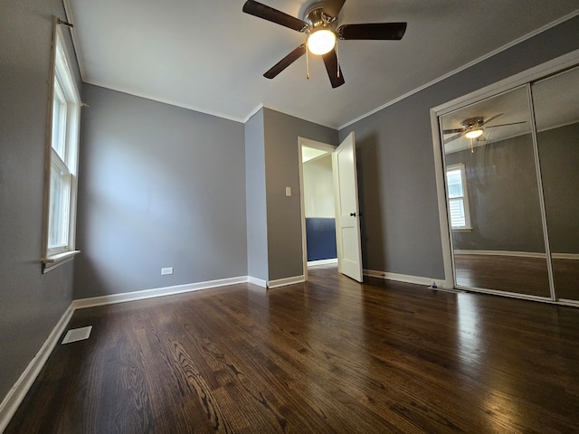 empty room with dark wood-type flooring, crown molding, and ceiling fan