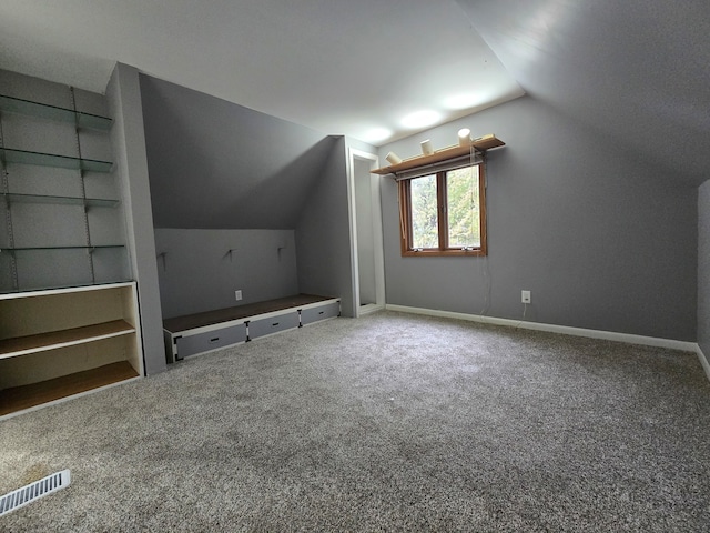 additional living space with lofted ceiling, carpet flooring, and built in shelves