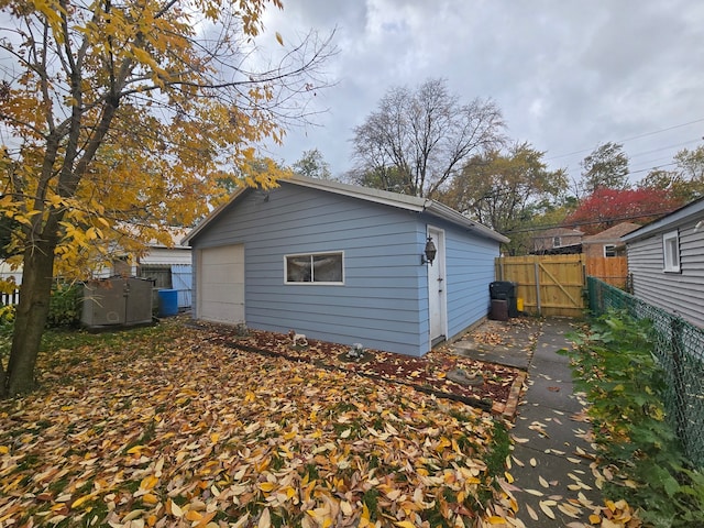 rear view of property featuring a garage and an outdoor structure