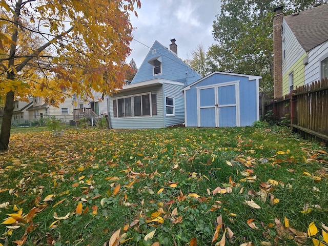 rear view of property featuring a shed