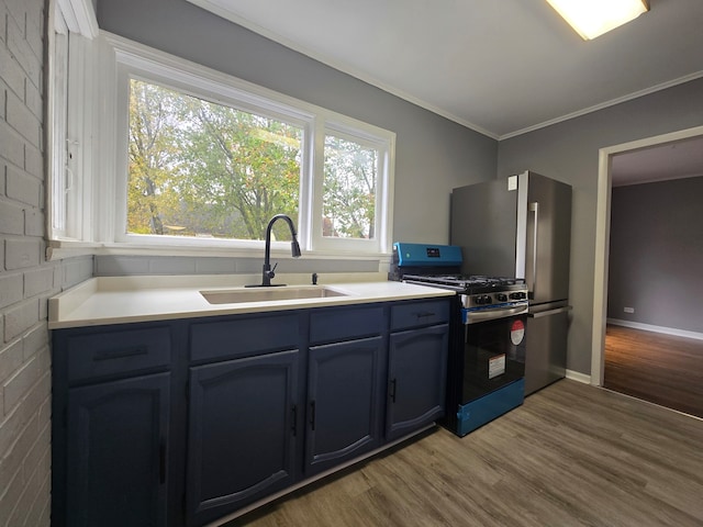 kitchen featuring sink, stainless steel fridge, black gas range, light hardwood / wood-style floors, and crown molding