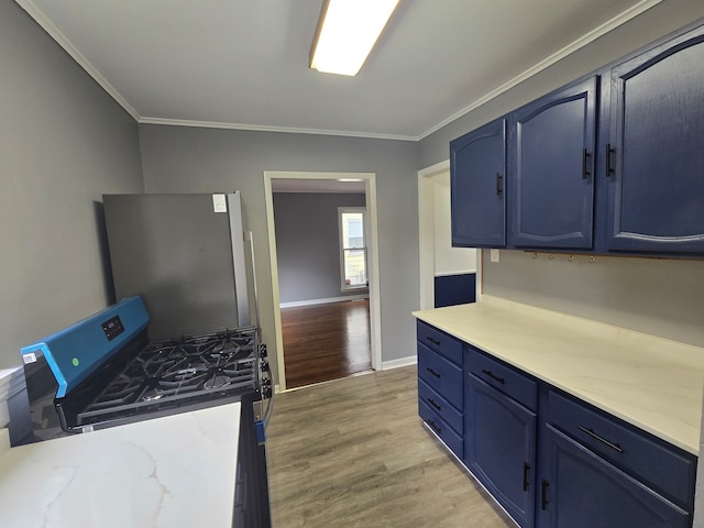 kitchen featuring blue cabinets, stainless steel fridge, crown molding, and light hardwood / wood-style floors