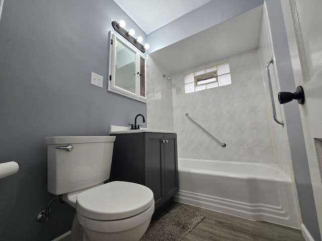 full bathroom with vanity, hardwood / wood-style floors, tiled shower / bath combo, and toilet