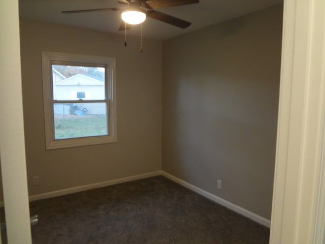 unfurnished room featuring dark colored carpet and ceiling fan