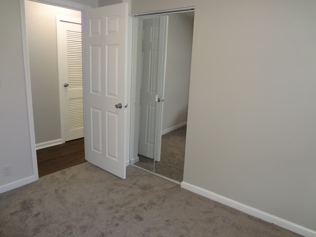 unfurnished bedroom featuring light carpet and a closet