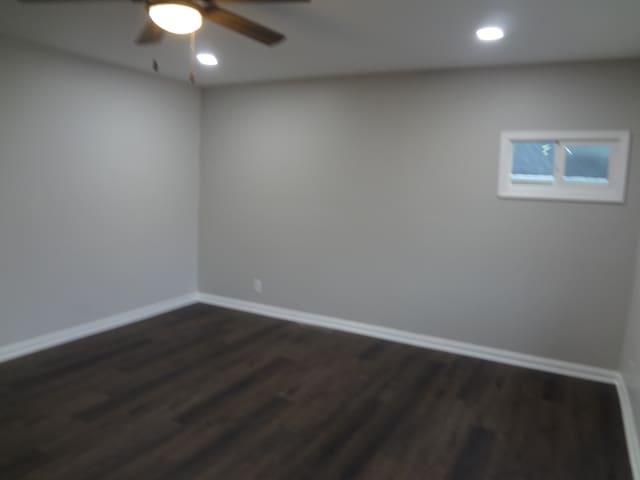 unfurnished room featuring dark wood-type flooring and ceiling fan