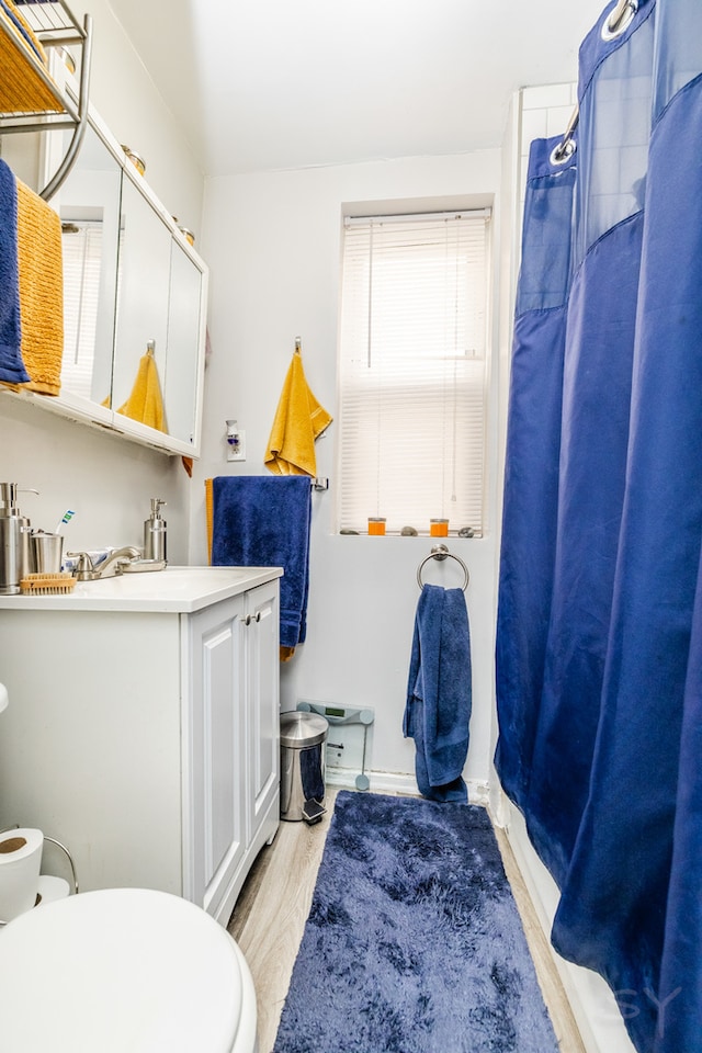 bathroom with a shower with shower curtain, wood-type flooring, and toilet