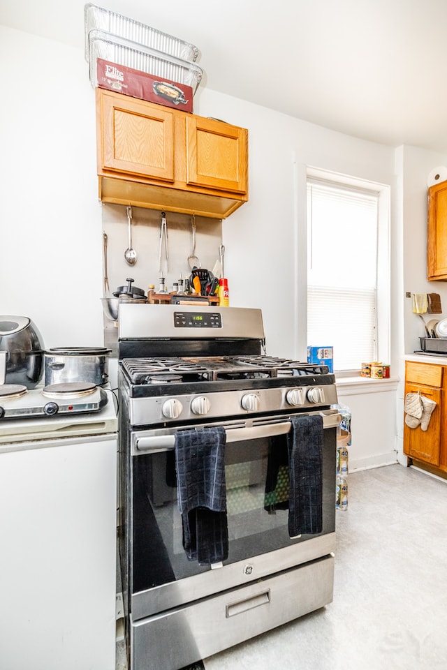 kitchen featuring gas range and light carpet