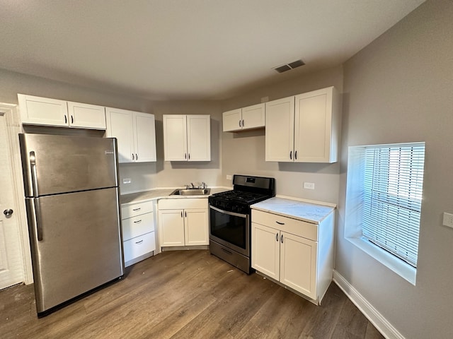 kitchen with white cabinets, hardwood / wood-style floors, and stainless steel appliances