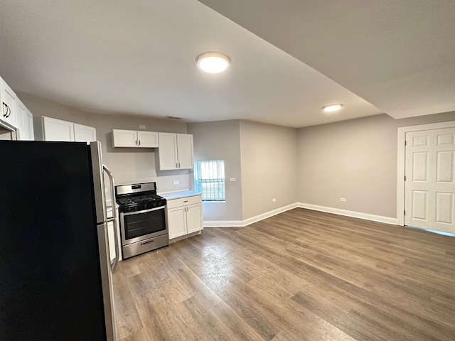 kitchen with light wood-type flooring, white cabinetry, stainless steel range, and fridge