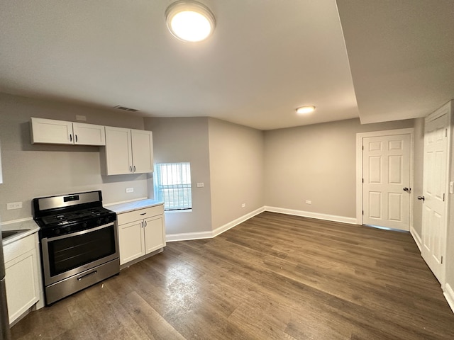 kitchen featuring stainless steel range oven, white cabinetry, and dark wood-type flooring