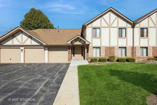 tudor house featuring a front yard and a garage