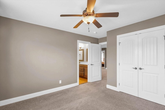 unfurnished bedroom with ceiling fan, a closet, light colored carpet, and ensuite bathroom