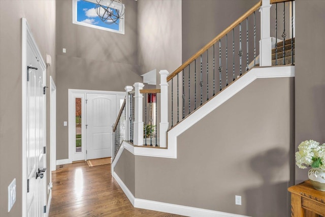 foyer entrance with hardwood / wood-style floors and a high ceiling