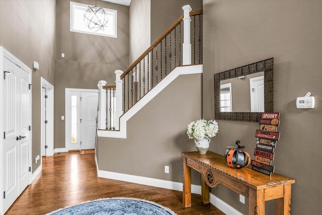 foyer featuring wood-type flooring and a towering ceiling