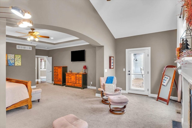 carpeted bedroom with a raised ceiling, ceiling fan, and crown molding