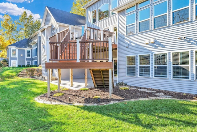 back of property with a deck and a lawn